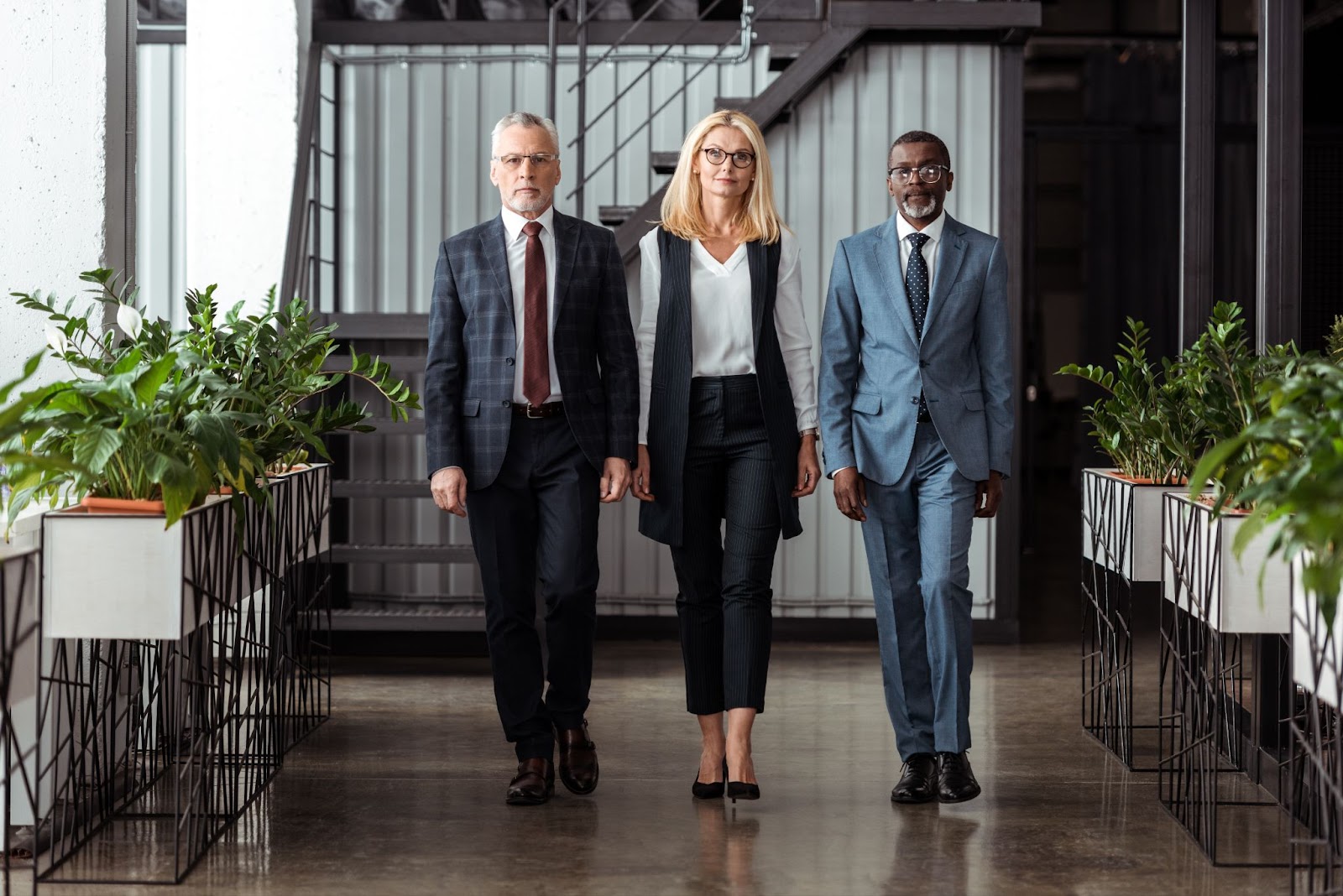 A businesswoman, along with two partners, walks into the office