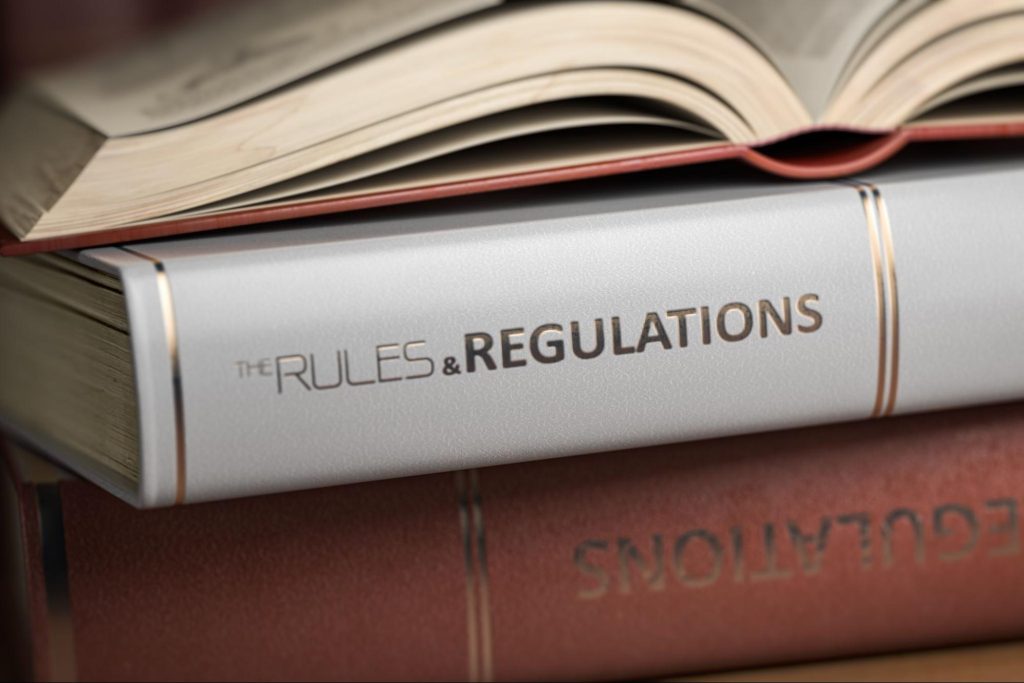 Book with a spine that reads “the rules and regulations.” 