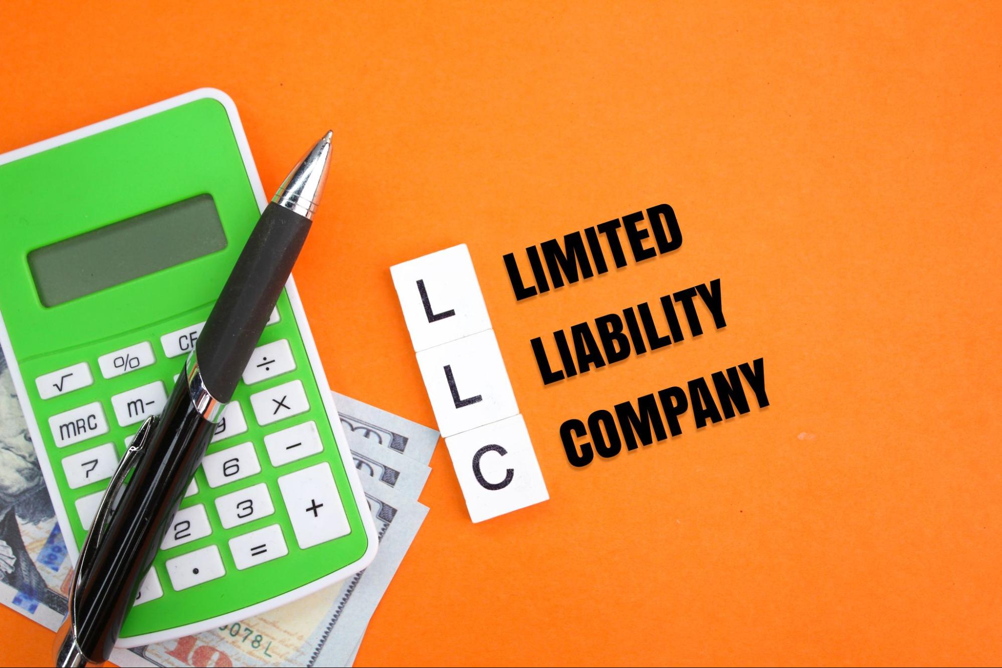 Calculator, pen, and dollar bills next to the acronym 'LLC' with each letter labeled ('L' for Limited, 'L' for Liability, 'C' for Company) on an orange background.